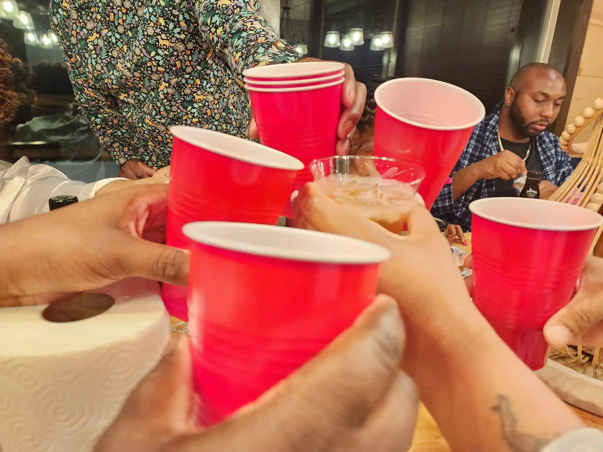 Friends raising red cups for a toast during the cabin trip in Gatlinburg, Tennessee.