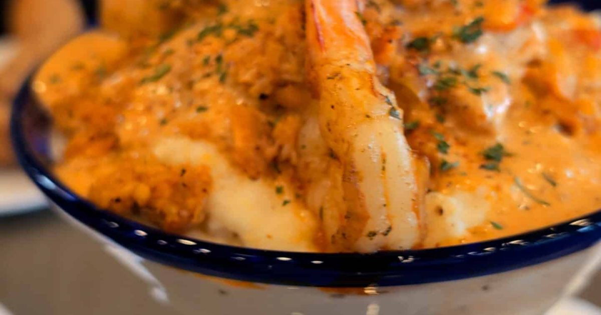 Close-up of the Ultimate Cajun Seafood & Grits served in a martini glass at Nouveau Bar & Grill in College Park.