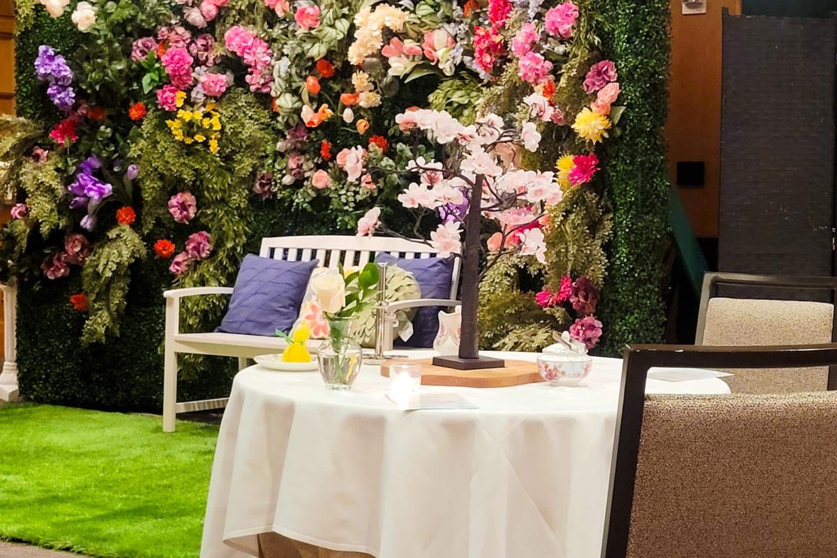 A table setup in front of a floral backdrop at Afternoon Spring Tea, Ritz Carlton Atlanta.