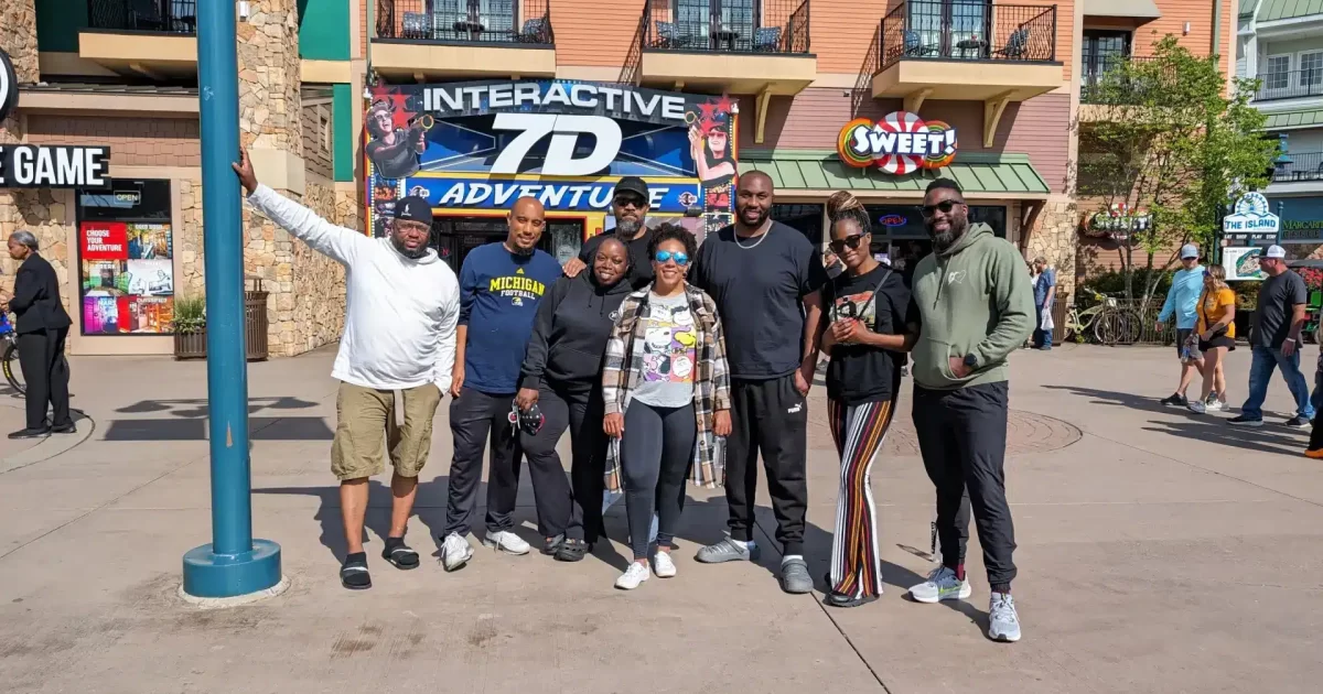 Dating Explained crew posing in front of an Interactive Adventure sign during a cabin trip in Pigeon Forge, Tennessee.