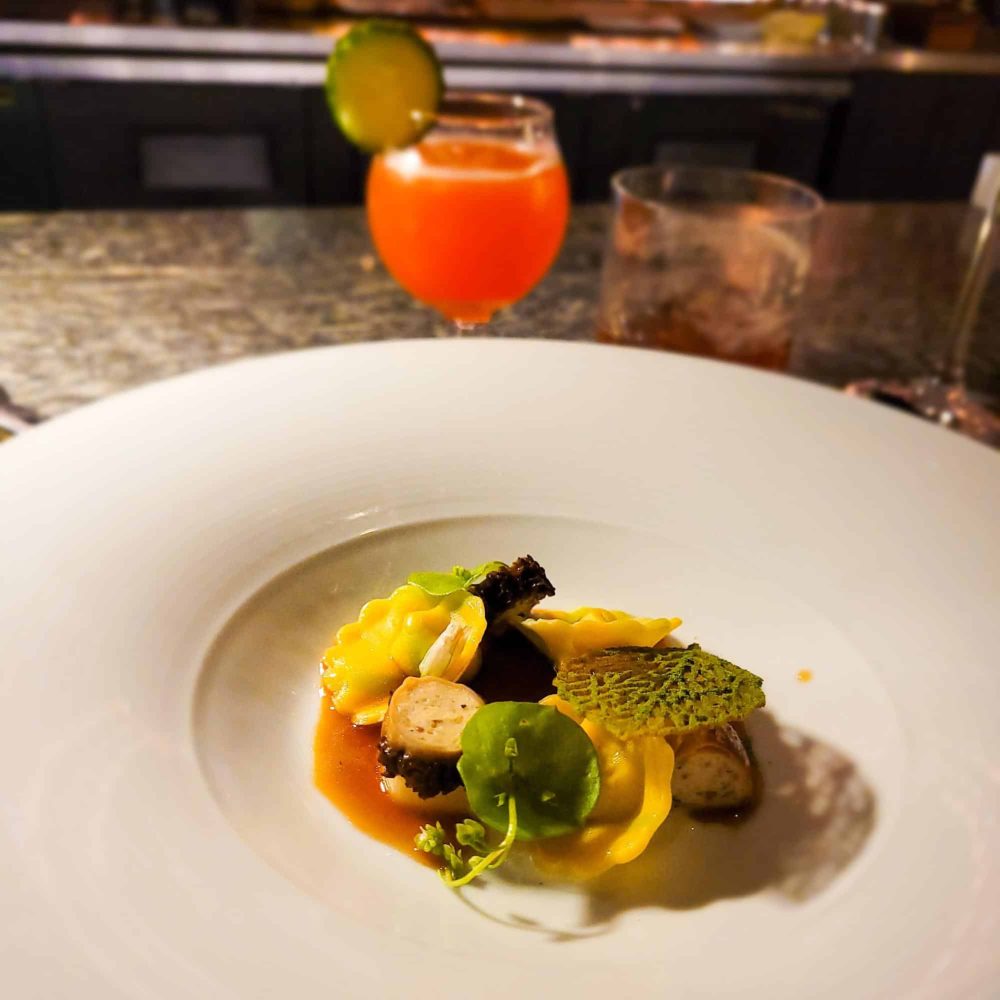 A dish of Spring Garlic Tortellini served with a Tomato Sour cocktail at Lazy Betty. Title: Spring Garlic Tortellini with Tomato Sour